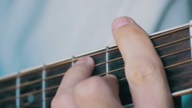 Adam akustik gitar çalıyor.
