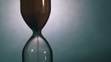 Beyaz arka plan üzerinde kum saati, kum içine düşüyor