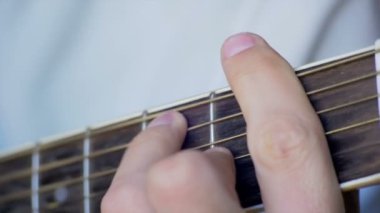 Adam akustik gitar çalıyor.