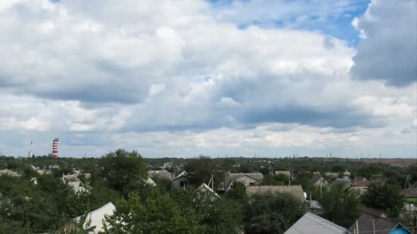 Облака в небе движутся по домам в городе — стоковое видео
