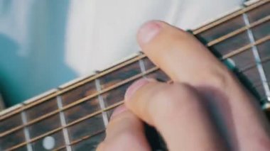 Adam akustik gitar çalıyor.