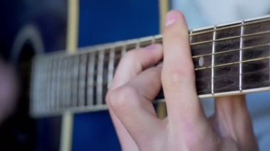 Adam akustik gitar çalıyor.