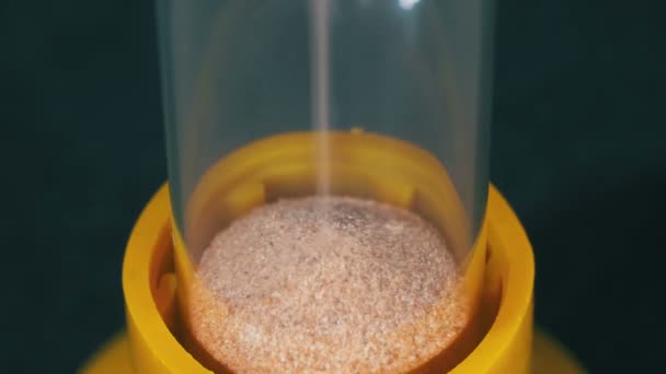 Sandglas auf schwarzem Hintergrund, der Sand fällt hinein — Stockvideo