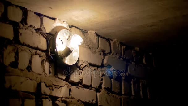 Bombilla incandescente se enciende apagado o hacia arriba en una pared de piedra — Vídeos de Stock