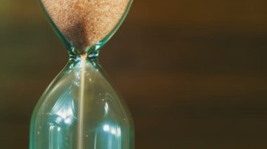 Ahşap arka plan üzerinde kum saati, kum içine düşüyor