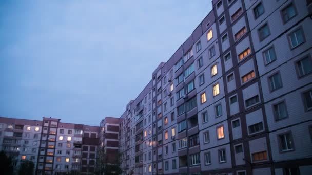 Многоэтажное здание с изменяющимся окном освещения ночью — стоковое видео