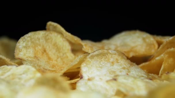 Aardappelchips draaien op zwarte achtergrond — Stockvideo