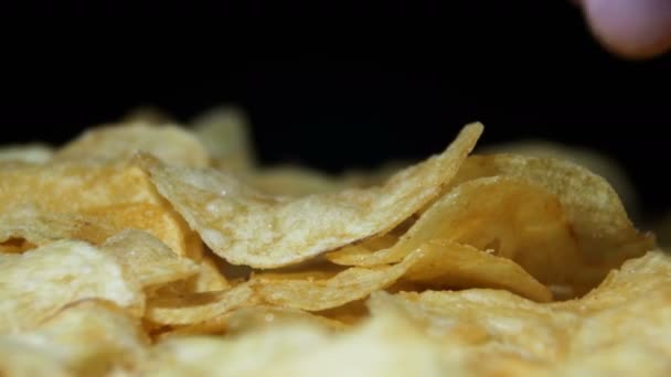 Chips de pomme de terre tournant sur fond noir — Video