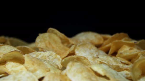 Aardappelchips draaien op zwarte achtergrond — Stockvideo