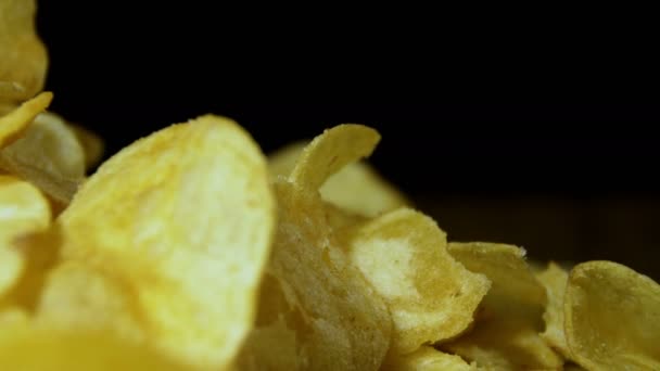 Patatas fritas girando sobre fondo negro — Vídeo de stock