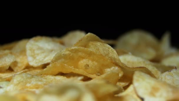 Aardappelchips draaien op zwarte achtergrond — Stockvideo