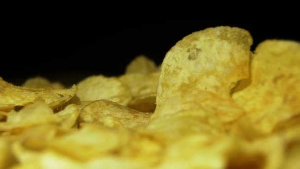 Kartoffelchips rotieren auf schwarzem Hintergrund — Stockvideo