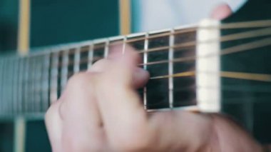 Adam akustik gitar çalıyor.