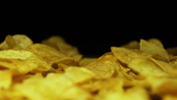 Kartoffelchips rotieren auf schwarzem Hintergrund — Stockvideo