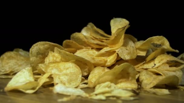 Chips de pomme de terre tournant sur fond noir — Video