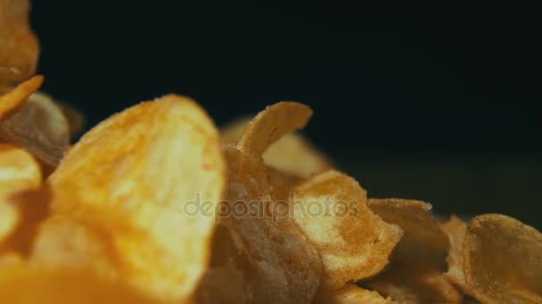 Patatas fritas girando sobre fondo negro — Vídeo de stock
