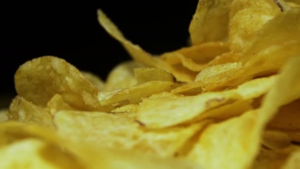 Chips de pomme de terre tournant sur fond noir — Video