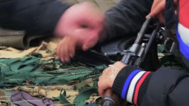 Masanın üzerinde ve askeri silah, otomatik makinelerde, el bombası, mühimmat, madde işaretleri vardır