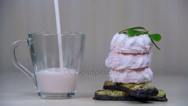 O iogurte é derramado em um vidro transparente em uma mesa de madeira em câmera lenta — Vídeo de Stock
