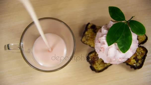 El yogur se vierte en un vaso transparente sobre una mesa de madera en cámara lenta — Vídeo de stock