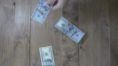 Ahşap bir masaya düşen Doları banknot. Ağır çekim
