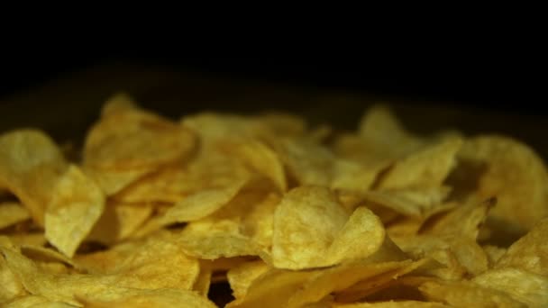 Chips de pomme de terre tournant sur fond noir au ralenti — Video