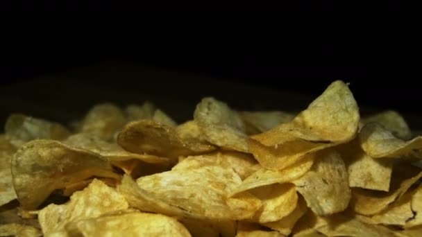 Chips de pomme de terre tournant sur fond noir — Video