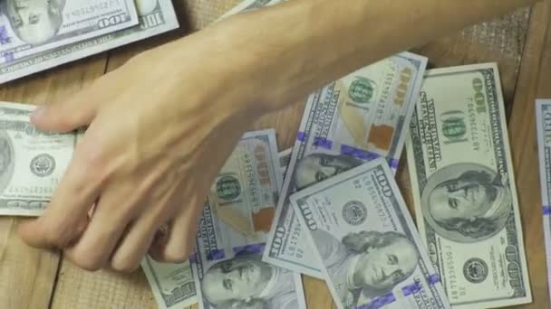 Billetes de dólar cayendo sobre una mesa de madera — Vídeo de stock