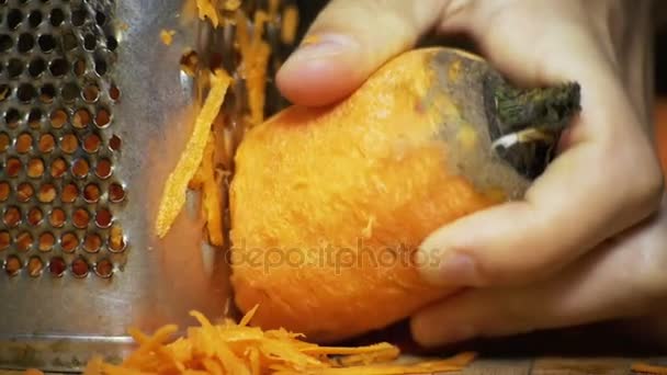 Τα καρότα σε ένα τρίφτη τρίβονται στην κουζίνα στο σπίτι. Αργή κίνηση — Αρχείο Βίντεο