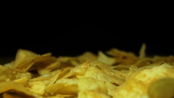 Man neemt de aardappel Chips met de hand op een houten tafel op zwarte achtergrond in Slow Motion — Stockvideo