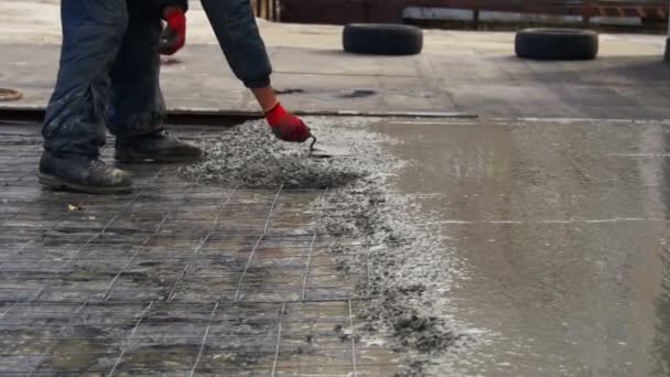 Выравнивание влажной бетонной поверхности с помощью металлической доски — стоковое видео