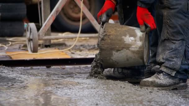 Derramando, deitando concreto no canteiro de obras usando baldes de cimento. Movimento lento — Vídeo de Stock
