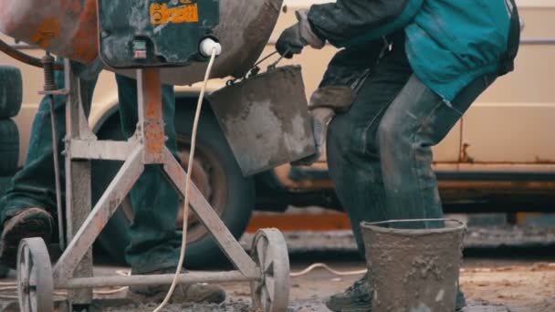 Betonmischer-Bauarbeiter und Arbeiter auf einer Baustelle. Zeitlupe — Stockvideo