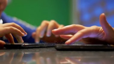 İnsanlarla bir Cafe masada oturan telefon ile oynayan çocuk.