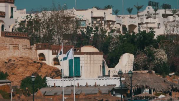 Egypten-flaggor som fladdrade i masten på bakgrund av Resort hotell. — Stockvideo