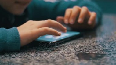 Hareket eden telefon ile masaya oynayan çocuk eller