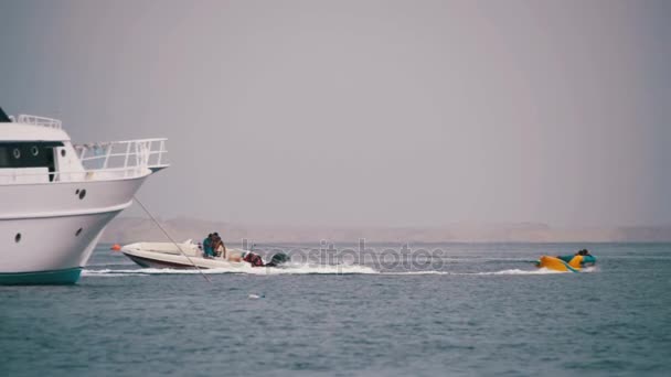 Води Extreme бампер трубки їзди позаду човен на Червоне море. Повільний рух — стокове відео