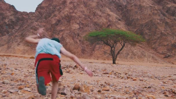 Perdido no deserto homem corre para a árvore verde e sombra — Vídeo de Stock