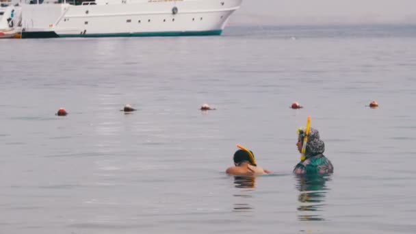 Mujer musulmana con máscara y snorkel y un niño en el Mar Rojo . — Vídeo de stock