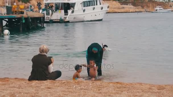 Bir maske ve şnorkel ve bir çocuk Red Sea'deki/daki Müslüman kadınla. — Stok video