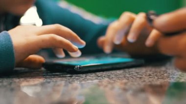 Hareket eden telefon ile masaya oynayan çocuk