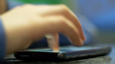 Hareket eden telefon ile masaya oynayan çocuk