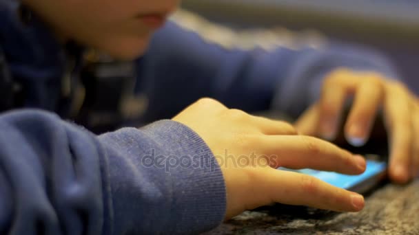 Mains Enfant jouant avec un téléphone portable sur la table — Video
