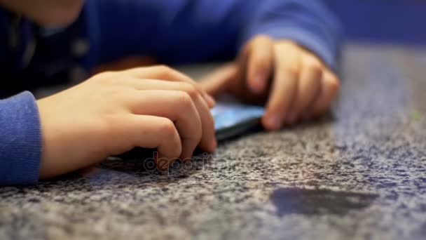テーブルの上の携帯電話で遊ぶ子供 — ストック動画