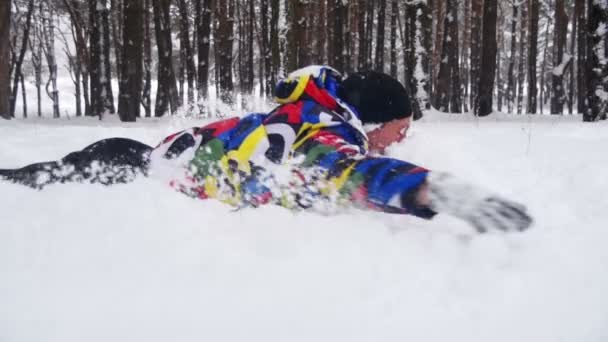 Homme plonge tête la première dans la neige profonde et amusez-vous dans la forêt d'hiver. Mouvement lent — Video
