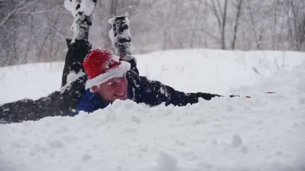 Человек ныряет головой в глубокий снег и веселится в зимнем лесу. Slow Motion — стоковое видео