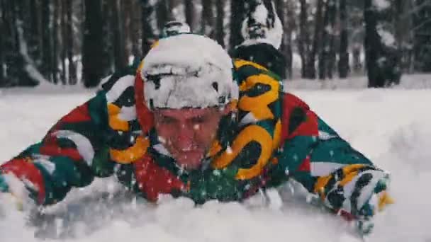 El hombre se sumerge primero en la nieve profunda y se divierten en el bosque de invierno. Moción lenta — Vídeos de Stock