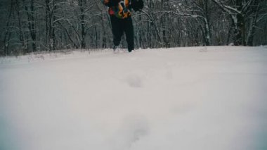 Karlı gün kış orman derin karda yürüyen adam. Ağır çekim