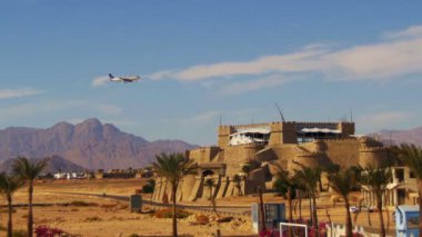 Yolcu uçağı gökyüzünde dağlar ve palmiye ağaçları Mısır arka plan üzerinde açılış.
