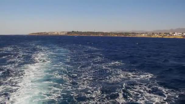 Лодка плывет по волнам и оставляет тропу в Красном море — стоковое видео